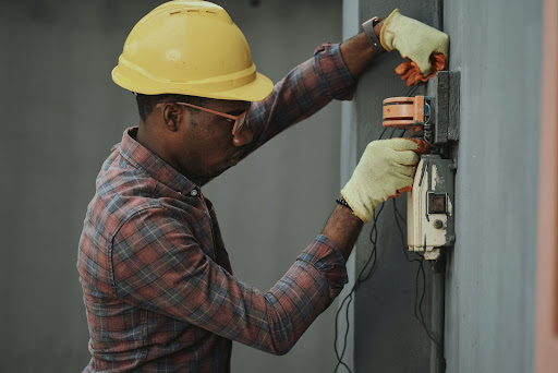 An electrician working with a hard hat on.